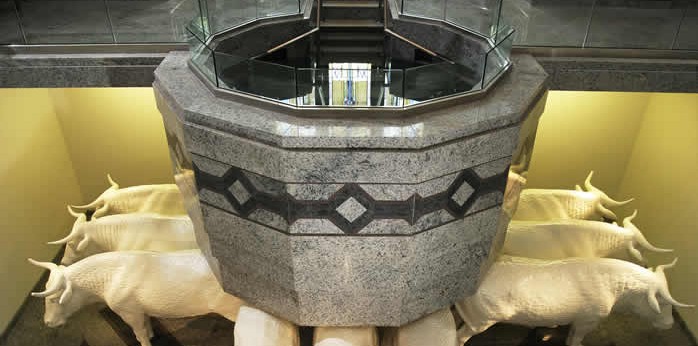 Why are baptismal fonts in temples usually built below ground?